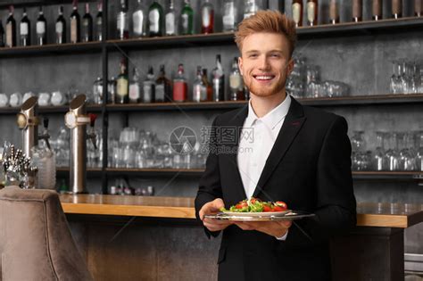 餐厅里有菜的年轻男服务员高清图片下载-正版图片503551697-摄图网