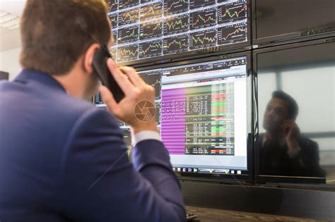 用手机交易股票的商人股票分析师在多个计算机屏幕上查看图表索引和数字股票交易员高清图片下载-正版图片502743580-摄图网
