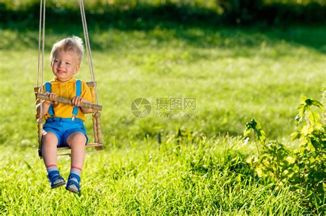 蹒跚学步的小男孩在后院荡秋千高清图片下载-正版图片507449395-摄图网