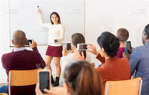 学生用智能手机上课，老师站在黑板前