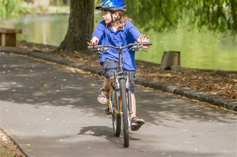 在自然公园背景下骑自行车的快乐青春期前男孩高清图片下载-正版图片505006474-摄图网