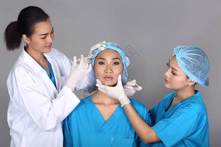 亚洲医生护士在整形手术前检查面部前额结构高清图片下载-正版图片506452455-摄图网
