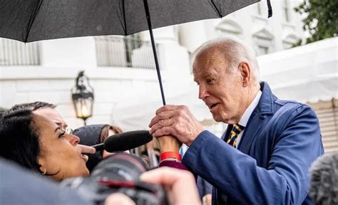 拜登雨中答记者问，一把握住女记者的手，躲入伞下！_凤凰网