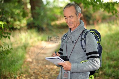 六十岁的老人在森林小径上做笔记高清摄影大图-千库网