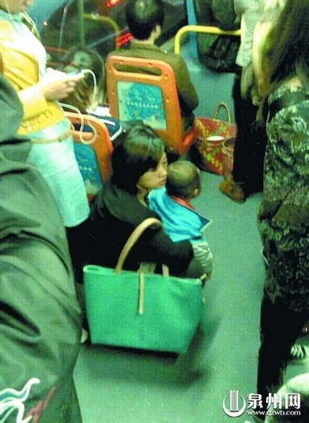 公交爱心专座上少女专注玩手机 妇女抱孩子蹲着 - 文明巡礼 - 东南网