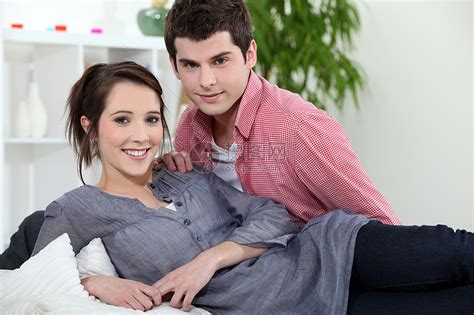 年轻夫妇躺在沙发上妻子机器亲热长椅电视植物丈夫男人女性夫妻高清图片下载-正版图片321254961-摄图网