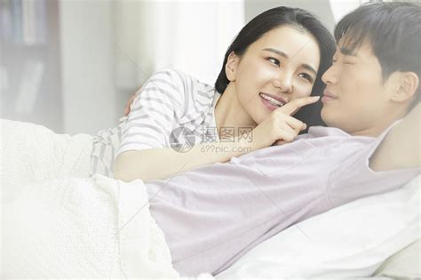年轻夫妻在卧室紧密拥抱躺在一起高清图片下载-正版图片502292529-摄图网