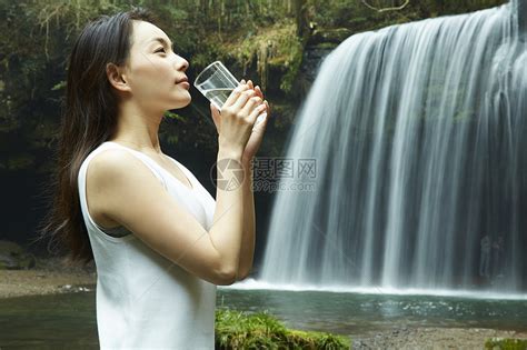 站在小溪边享受瀑布的女人在喝水高清图片下载-正版图片502071630-摄图网