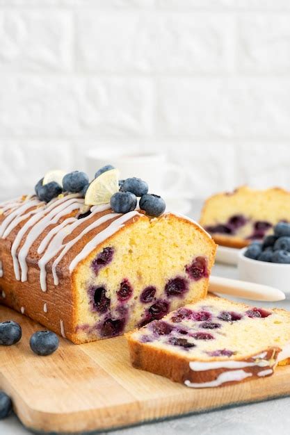 Premium Photo | Lemon blueberry cake with lemon icing and fresh berries ...