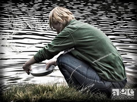 Young blonde woman washing dishes in aluminum river, Stock Photo ...