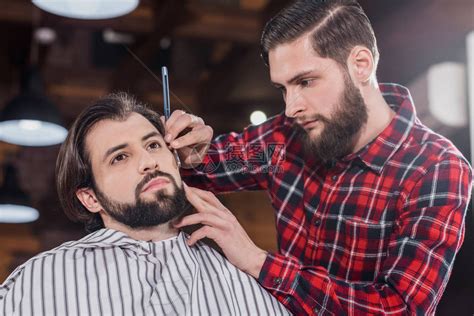 有自信的年轻理发师穿着格子衬衣剃胡子的男人高清图片下载-正版图片502656202-摄图网