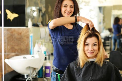 女理发师手拿着梳子和头发锁给漂亮的金发访客做发型角蛋白修复最新趋势新鲜理念新剪发高清图片下载-正版图片504952643-摄图网