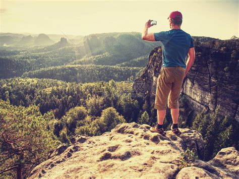 业余爱好者用智能手机在岩石峰上拍照高清图片下载-正版图片505470067-摄图网