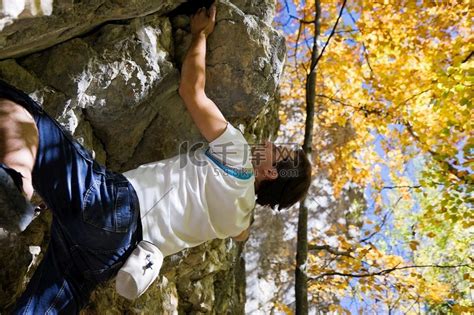一个人在到达山顶前不久就爬上了岩石高清摄影大图-千库网