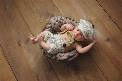 一个警觉的3周大的新生男婴穿着钩针编织的小男人西装高清图片下载-正版图片502570936-摄图网