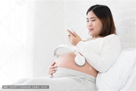 在手机应用程序上为母亲和未出生的婴儿听怀孕音乐,摄影素材,汇图网www.huitu.com