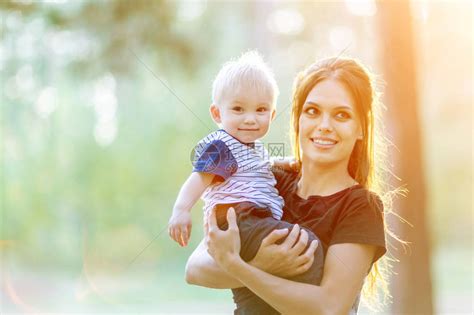 妈和宝在一起年轻的母亲拥抱儿子带着孩子在公园散步的女人高清图片下载-正版图片502520341-摄图网