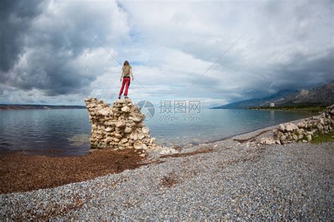 女孩双手举起站在一堆石头上高清图片下载-正版图片506190144-摄图网