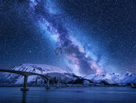 桥星空与银河雪覆盖的山脉反射水中夜间景观与道路,雪岩,紫色的天空与星星银河,海洋挪威洛福滕岛的冬天高清图片下载-正版图片300877711-摄图网