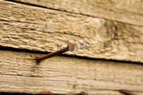 锤在带有金属末端的木柄上在木质表面上钉子金属钉子被钉进一块蓝色的木板上用锤子高清图片下载-正版图片507509850-摄图网