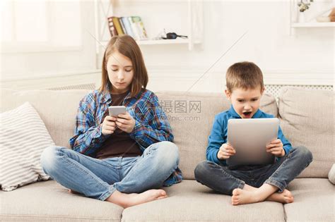 弟弟和妹妹玩电子游戏高清摄影大图-千库网