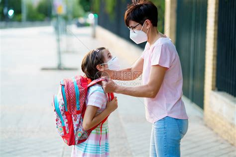 母亲准备让女儿带着面具返回学校高清图片下载-正版图片503710167-摄图网