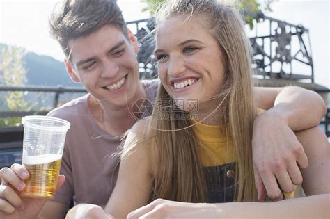 在屋顶露台派对上喝酒的年轻夫妇高清图片下载-正版图片501873749-摄图网