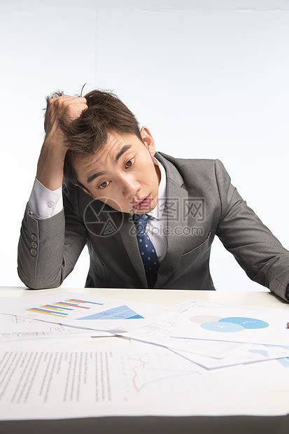 筋疲力尽，工作过度的成熟的办公室职员坐在工作场所，严重的头痛按摩他的头。不健康的视频素材_ID:VCG42N1404188342-VCG.COM