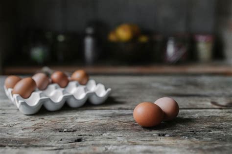 Huevos de gallina frescos en una caja y sobre una mesa de madera | Foto ...