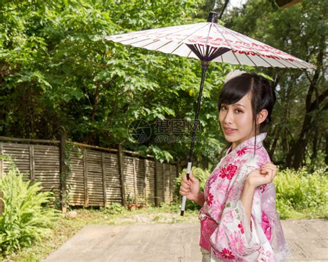 女和服的亚洲人在日本风格的花园里拿着雨伞戏服趋势高清图片下载-正版图片307917018-摄图网