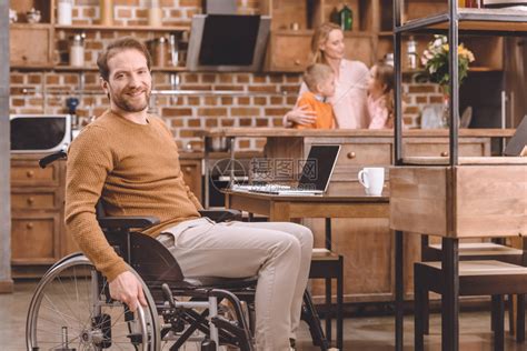 坐在轮椅上的残疾中年男子在家里与家人共度时光高清图片下载-正版图片502701558-摄图网