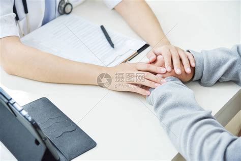 年轻的亚洲女医生用在医务室的手抚慰老年男病人高清图片下载-正版图片505051553-摄图网