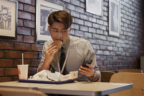 职场男性吃饭时看手机高清图片下载-正版图片501773400-摄图网