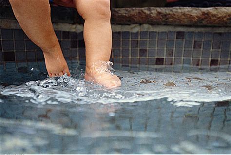 两个女孩趴在划水池边用脚扑腾水高清图片下载-正版图片501865763-摄图网