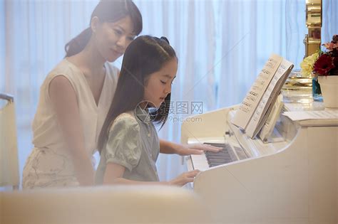 钢琴老师在指导女孩练琴高清图片下载-正版图片502065889-摄图网
