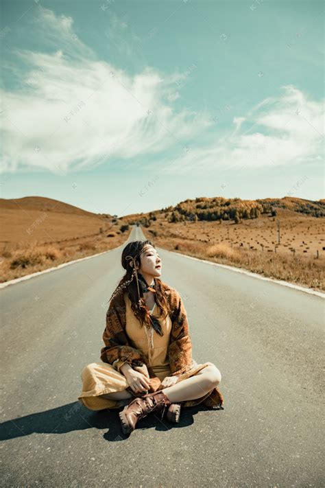 坐在草原公路上的女孩高清摄影大图-千库网