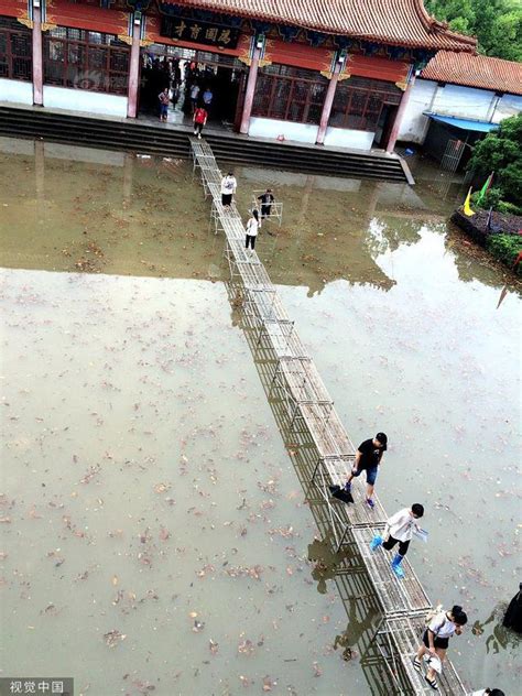 江西上饶遭遇暴雨考点被淹 校方用课桌拼出高考生通行之“桥”_新浪图片
