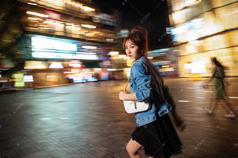 夜晚行走的路上的青年女人高清摄影大图-千库网