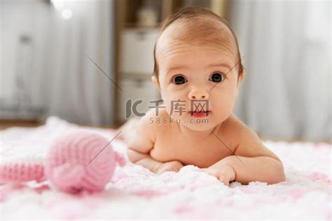 婴儿期和人的概念-甜美的小女婴躺在毛绒纱针织粉红色毯子上。高清摄影大图-千库网