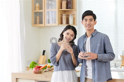 年轻情侣在厨房拿水杯喝水高清图片下载-正版图片501555891-摄图网