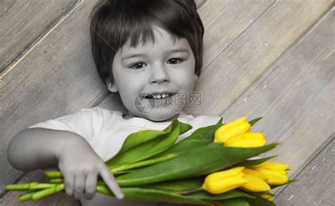 一个拿着一束黄色郁金香的小孩一个男孩拿着花瓶里的鲜花礼物给女假期女孩的礼物高清图片下载-正版图片506237979-摄图网