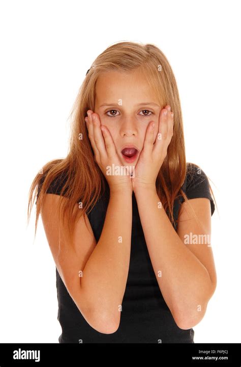 A very scared looking young girl with her mouth open and her hands on ...