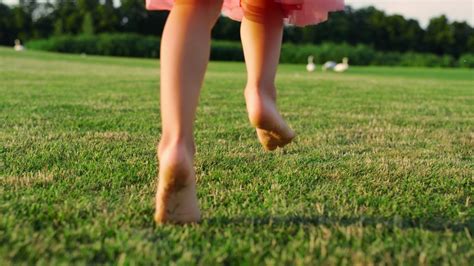 孩子们的脚踩在公园的绿草地上。高清摄影大图-千库网