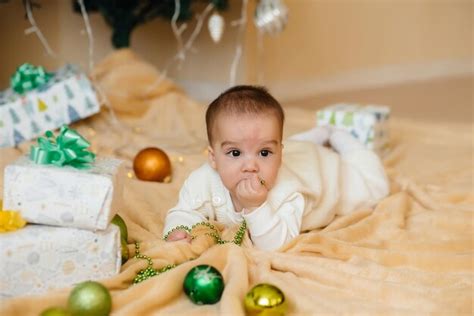 Premium Photo | Cute smiling baby is lying under a festive christmas ...