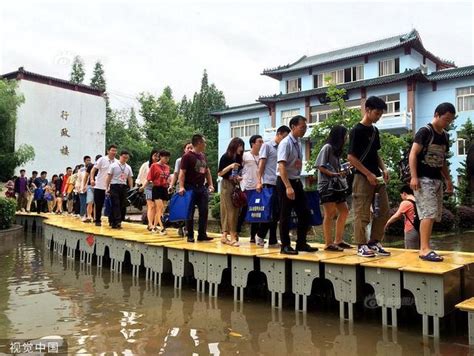 江西上饶遭遇暴雨考点被淹 校方用课桌拼出高考生通行之“桥”_新浪图片