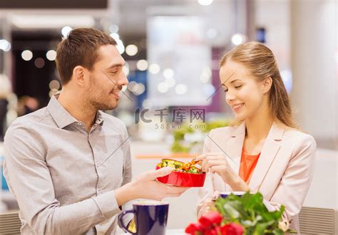 快乐的情侣在商场里带着礼物和鲜花高清摄影大图-千库网