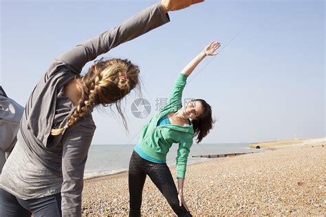 两个女人在布赖顿海滩上做手臂弯曲热身运动高清图片下载-正版图片501862842-摄图网