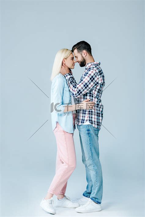 美丽的年轻夫妇拥抱和看着对方的灰色高清摄影大图-千库网