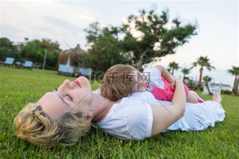 年轻的母亲和可爱的小女儿享受在后院草地上玩耍的空闲时间，自然概念中的幸福家庭高清摄影大图-千库网