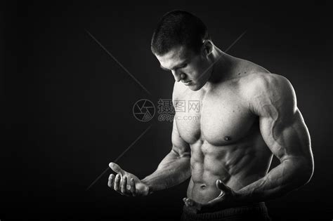 专业的健美运动员在深色背景上展示了他的身体肌肉男显示肌肉紧张对结果感到自豪体育杂志海报高清图片下载-正版图片507544632-摄图网